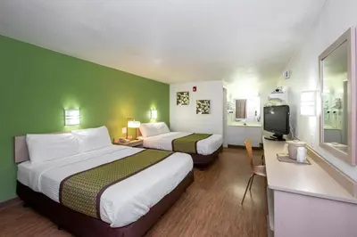 a hotel room with two beds and a television at American Inn in Carlisle