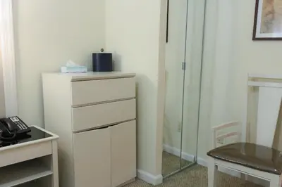 a room with a dresser and a desk with a phone at Da Vinci Hotel in New York
