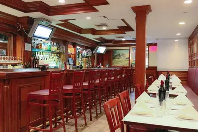 a restaurant with a bar with tables and chairs at Da Vinci Hotel in New York