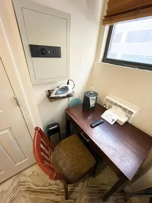 a room with a desk with a telephone and a chair at Da Vinci Hotel in New York