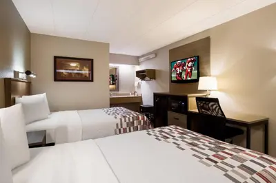 a hotel room with two beds and a desk at Red Roof Inn Wilkes-Barre Arena in Wilkes-Barre