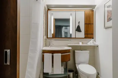a bathroom with a sink and a toilet and a mirror at Club Quarters Hotel Grand Central, New York in New York