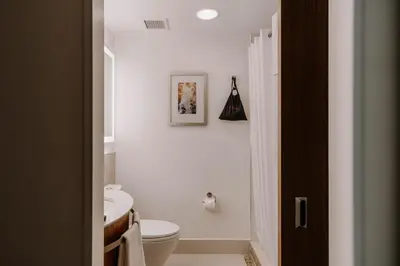 a white bathroom with a toilet and a sink at Club Quarters Hotel Grand Central, New York in New York