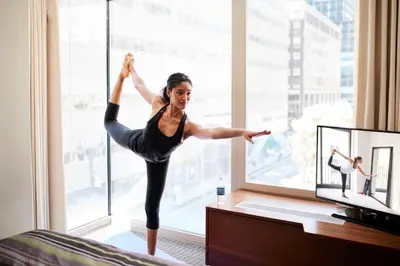 a woman doing a yoga pose in front of a window at Club Quarters Hotel Grand Central, New York in New York