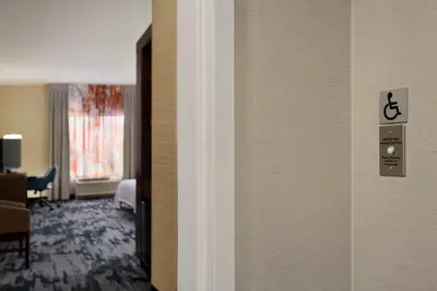 a room with a door with a handicap sign on the wall at Fairfield Inn & Suites by Marriott Hershey Chocolate Avenue in Hershey
