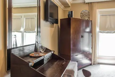 a room with a large wooden dresser with a mirror at The Peacock Inn, an Ascend Collection Hotel in Princeton