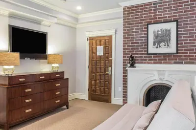 a living room with a fireplace and a tv at The Peacock Inn, an Ascend Collection Hotel in Princeton
