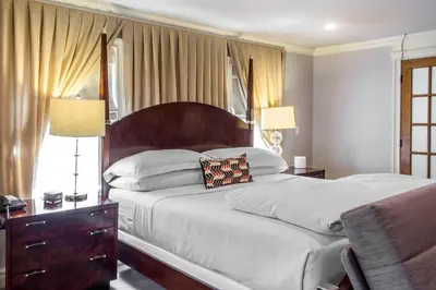 a bedroom with a large bed with a wooden headboard at The Peacock Inn, an Ascend Collection Hotel in Princeton
