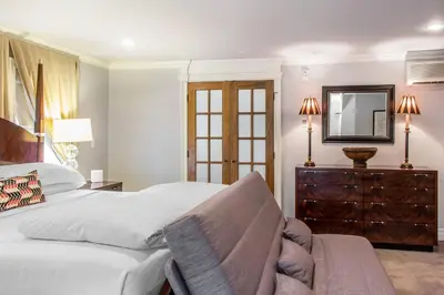 a bedroom with a bed and a dresser and a mirror at The Peacock Inn, an Ascend Collection Hotel in Princeton