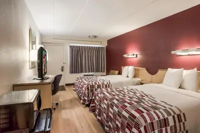 a hotel room with two beds and a flat screen tv at Red Roof Inn Philadelphia - Trevose in Trevose