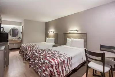 a hotel room with two beds and a desk at Red Roof Inn Philadelphia - Trevose in Trevose