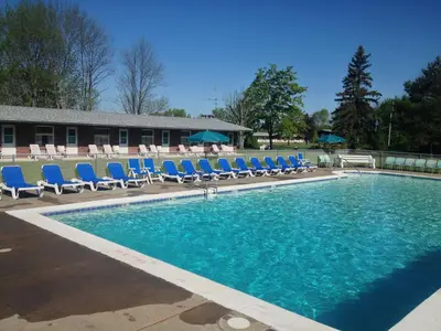 a large swimming pool with blue chairs and blue chairs at Lukans Farm Resort in Hawley