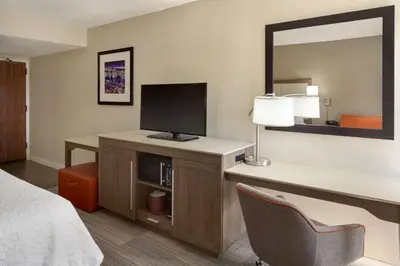 a hotel room with a bed and a desk with a television at Hampton Inn Philadelphia/Mt. Laurel in Mount Laurel