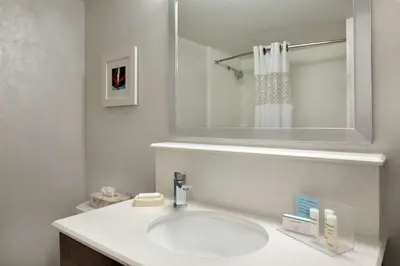 a white bathroom with a sink and a mirror at Hampton Inn Philadelphia/Mt. Laurel in Mount Laurel