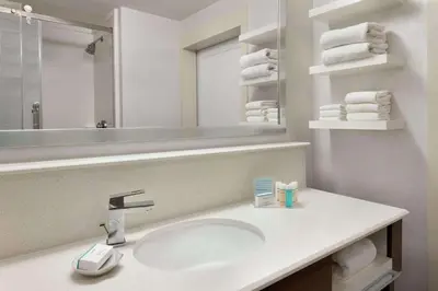 a bathroom with a sink and a mirror and towels at Hampton Inn Philadelphia/Mt. Laurel in Mount Laurel