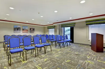 a conference room with blue chairs and a podium at Hampton Inn & Suites Newark-Harrison-Riverwalk in Newark