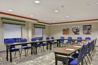 a conference room with tables and blue chairs at Hampton Inn & Suites Newark-Harrison-Riverwalk in Newark