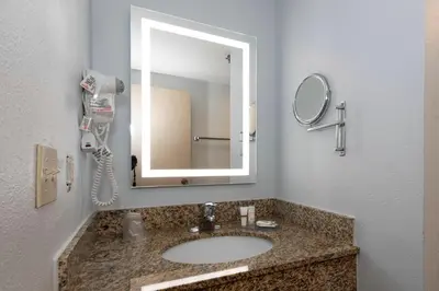 a bathroom with a sink and a mirror at Red Roof Inn & Suites Wilmington – New Castle in New Castle