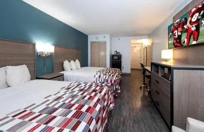 a hotel room with two beds and a television at Red Roof Inn & Suites Wilmington – New Castle in New Castle