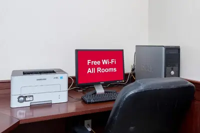 a desk with a computer and a monitor and a printer at Red Roof Inn & Suites Wilmington – New Castle in New Castle