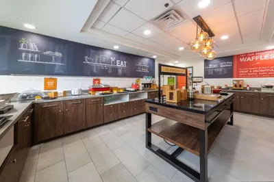 a large kitchen with wooden cabinets and a counter at Hampton Inn Swedesboro Philadelphia in Swedesboro