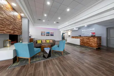 a waiting room with blue chairs and a couch at Hampton Inn Swedesboro Philadelphia in Swedesboro
