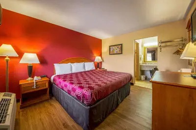 a hotel room with a bed with a red wall at Econo Lodge Mount Laurel - Philadelphia East in Mount Laurel