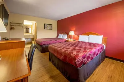 a hotel room with two beds and a red wall at Econo Lodge Mount Laurel - Philadelphia East in Mount Laurel
