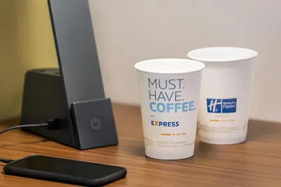 two coffee cups sitting on a desk next to a computer at Holiday Inn Express & Suites Philadelphia - Mt Laurel by IHG in Mount Laurel