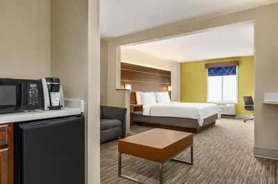 a large hotel room with a bed and a kitchen at Holiday Inn Express & Suites Philadelphia - Mt Laurel by IHG in Mount Laurel