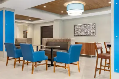 a waiting room with blue chairs and tables at Holiday Inn Express & Suites Philadelphia - Mt Laurel by IHG in Mount Laurel
