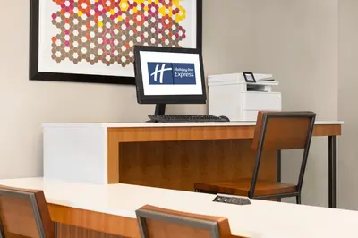 a computer sitting on top of a desk with chairs at Holiday Inn Express & Suites Philadelphia - Mt Laurel by IHG in Mount Laurel