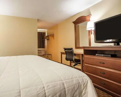 a hotel room with a bed and a flat screen tv at Econo Lodge Newton in Newton