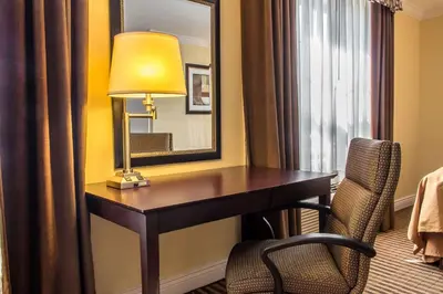 a desk in a hotel room with a lamp and a chair at Quality Inn near Mountain Creek in Vernon