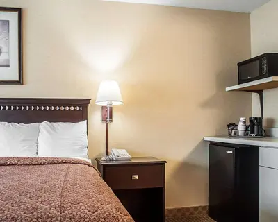 a hotel room with a bed and a telephone at Econo Lodge Elmira-Corning in Elmira