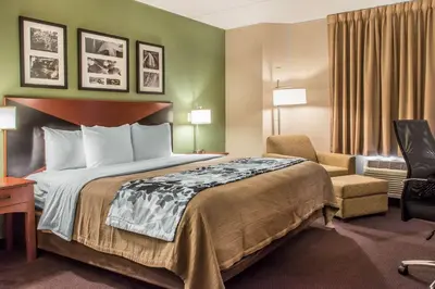 a hotel room with a bed and a chair at Sleep Inn & Suites of Lancaster County in Mountville