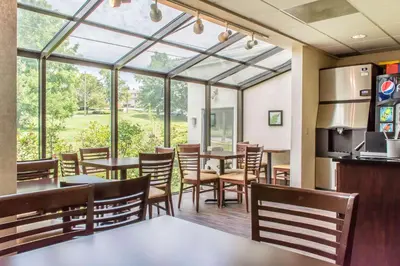 a dining room with tables and chairs and windows at Sleep Inn & Suites of Lancaster County in Mountville