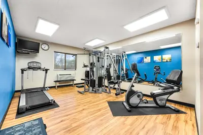 a gym with treadmills and exercise equipment in a room at SureStay Plus by Best Western Reading North in Reading
