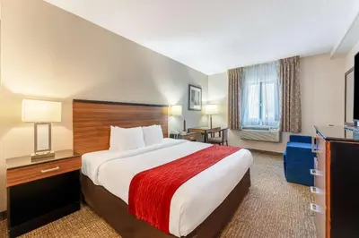 a hotel room with a large bed with a red blanket at SureStay Plus by Best Western Reading North in Reading