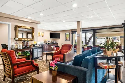 a living room with a blue couch and chairs at SureStay Plus by Best Western Reading North in Reading