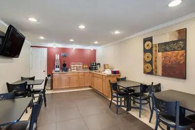 a restaurant with tables and chairs and a kitchen at Rodeway Inn Carlisle North in Carlisle