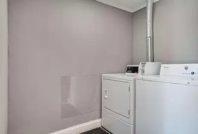 a white laundry room with a washer and dryer at Rodeway Inn Carlisle North in Carlisle