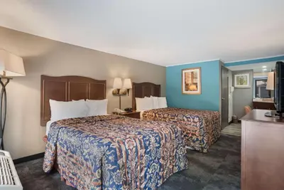 a hotel room with two beds with blue walls at Rodeway Inn Carlisle North in Carlisle