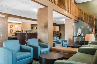 a waiting room with blue chairs and tables at Comfort Inn Pine Grove I-81 Hershey Area in Pine Grove