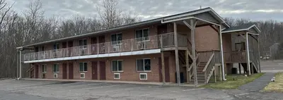 a large red brick building with a balcony at Econo Lodge Drums in Drums