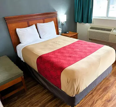 a bedroom with a large bed with a red blanket at Econo Lodge Drums in Drums