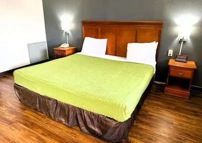 a large bed in a hotel room with two night stands at Econo Lodge Drums in Drums