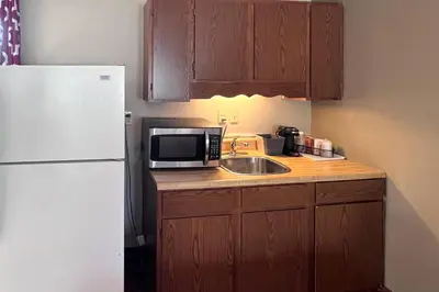a kitchen with a sink and a white refrigerator at Rodeway Inn & Suites Hershey Chocolate Avenue in Hershey