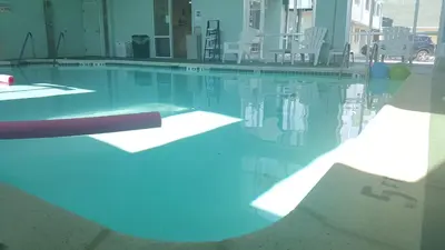 a swimming pool with blue lights in a building at Rodeway Inn & Suites Hershey Chocolate Avenue in Hershey