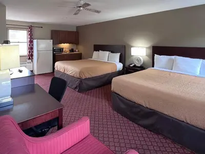a hotel room with two beds and a desk at Rodeway Inn & Suites Hershey Chocolate Avenue in Hershey